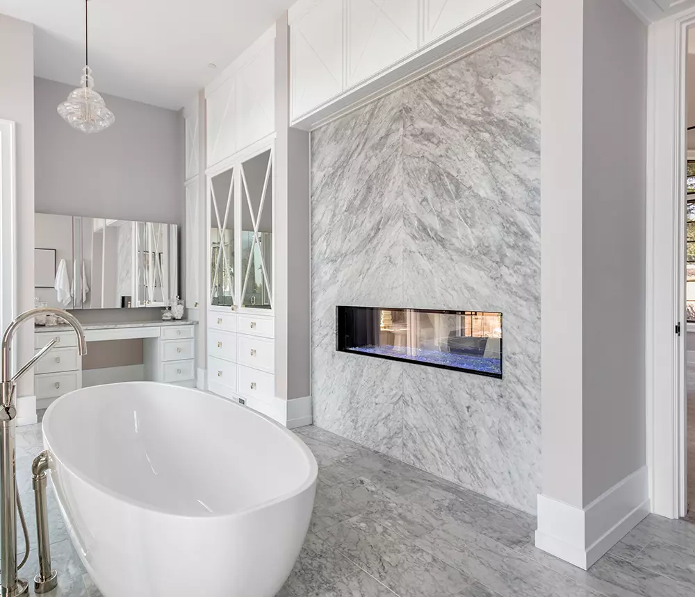 Modern luxurious bathroom renovation in Vacnouver, BC, with marble walls and freestanding tub