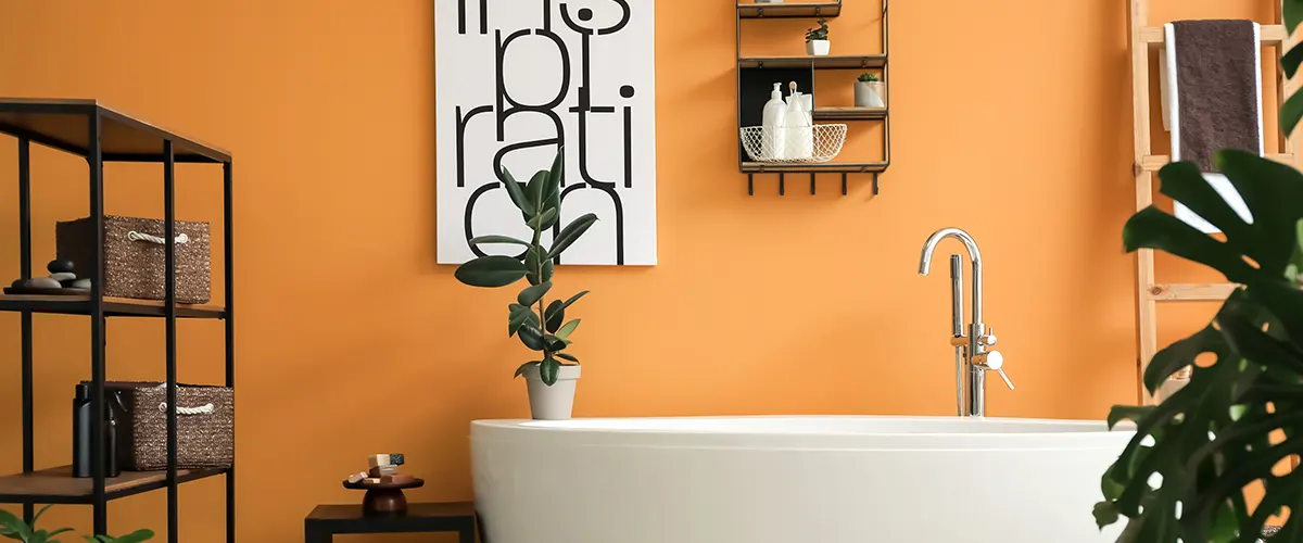Bright orange bathroom walls with modern furniture, freestanding tub, and green plants