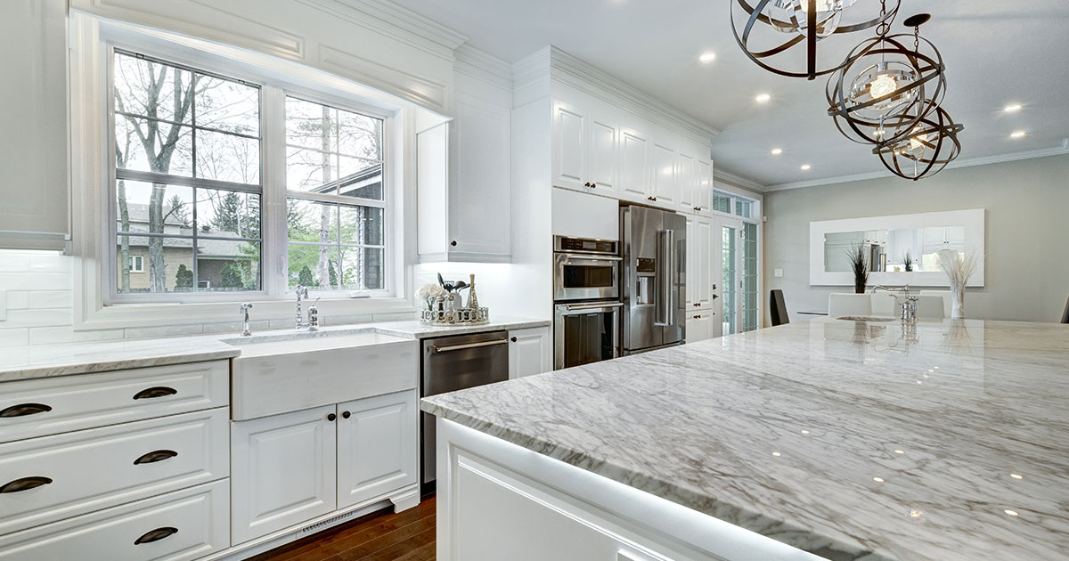 Newly upgraded kitchen in Metro Vancouver with white cabinets, quartz countertops, and large view on large sink window