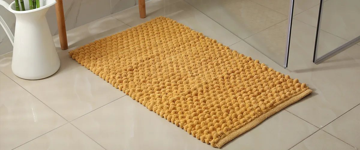 Tile flooring with a yellow bath carpet