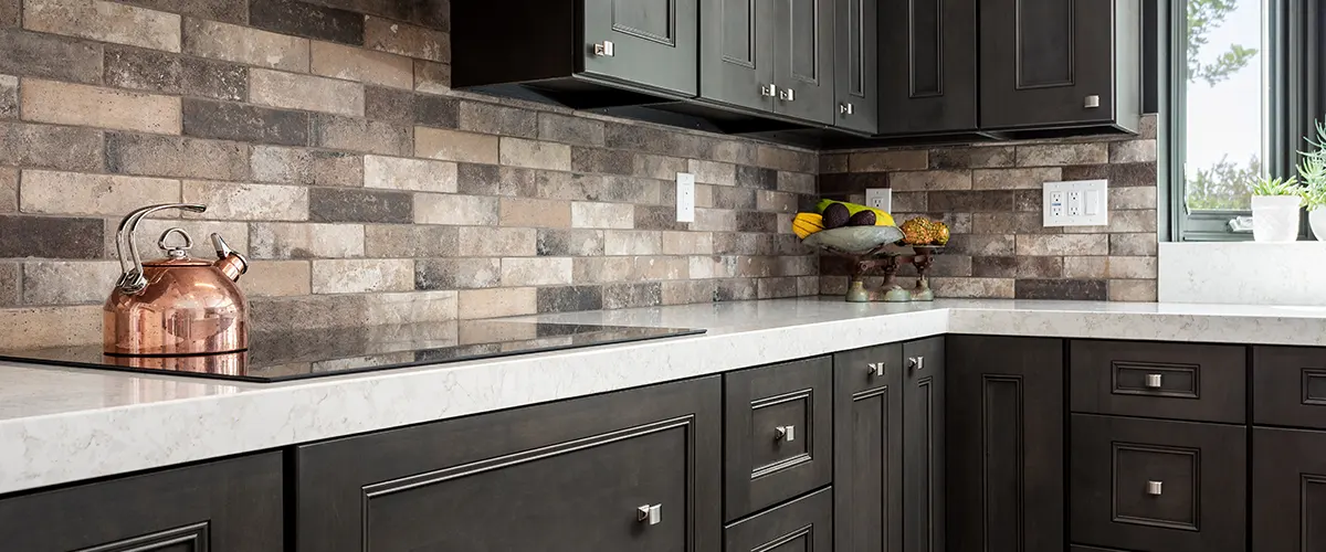 Black elegant cabinets in a kitchen with stone backsplash