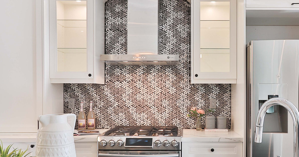 Intricate geometric kitchen backsplash behind a new stainless steel stove