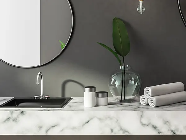 A marble countertop in a bath with black walls