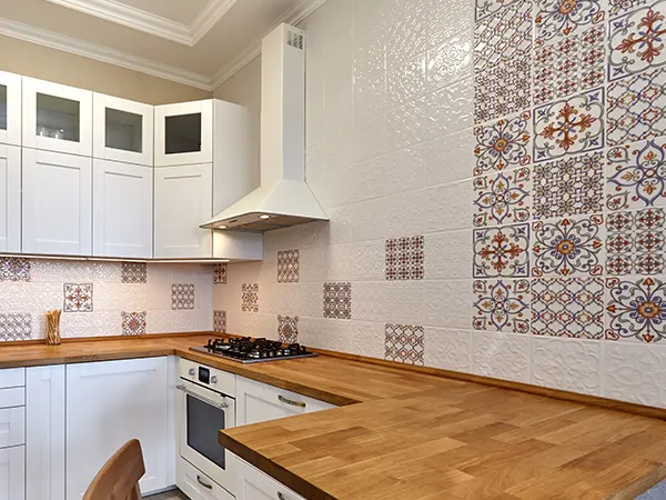 Modern white kitchen renovation with white tile and intricate oriental backsplash pattern
