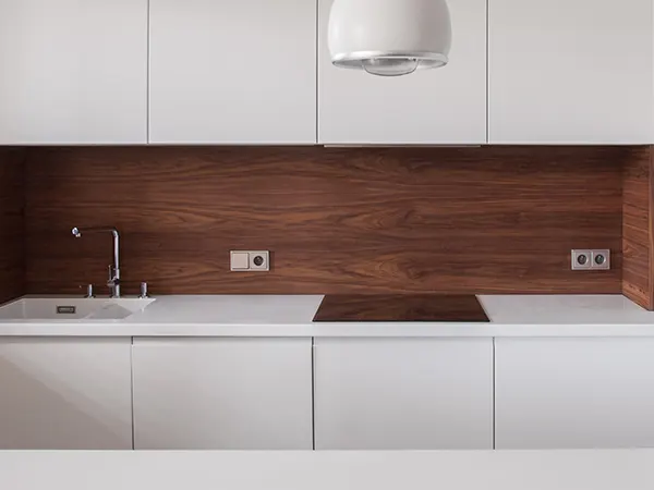 Minimalist kitchen with simple white cabinets and dark wood backsplash