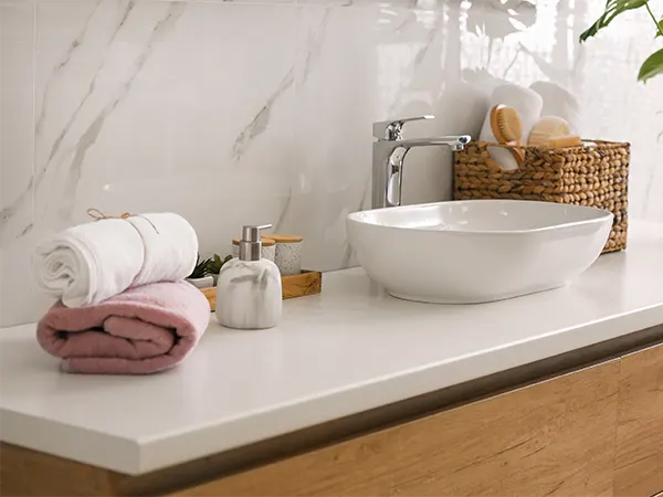 A quartz countertop with towels and a vessel sink