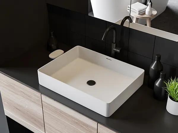 Dark countertop with a white sink and dark faucet