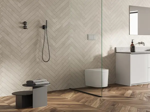 Walk-in shower in a modern bathroom with hardwood herringbone flooring and cream bathroom wall tile