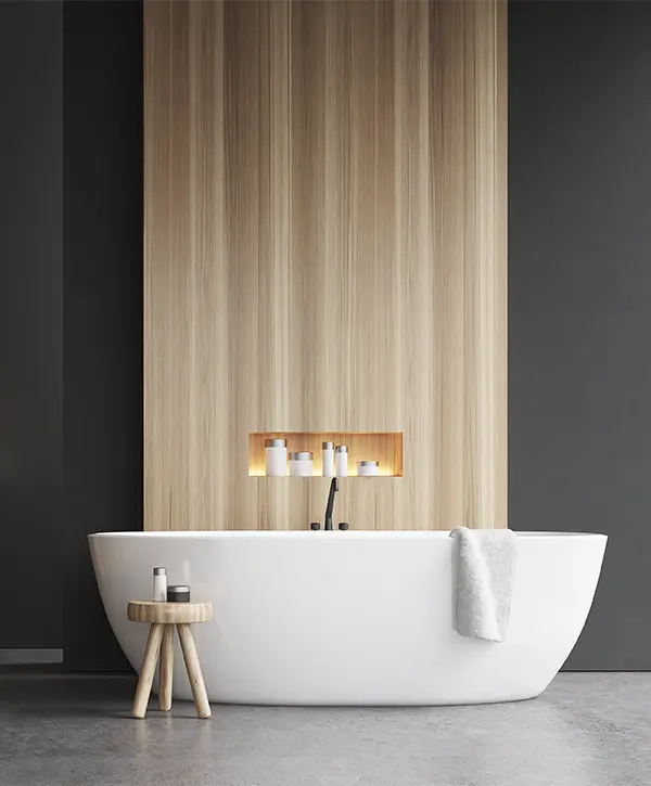 A white freestanding tub in a bath with dark walls