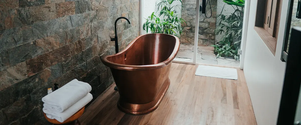 wood flooring in small bathroom with tub