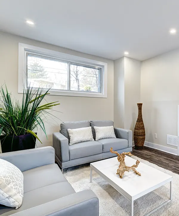 basement renovation aldergrove with gray couches and off-white walls